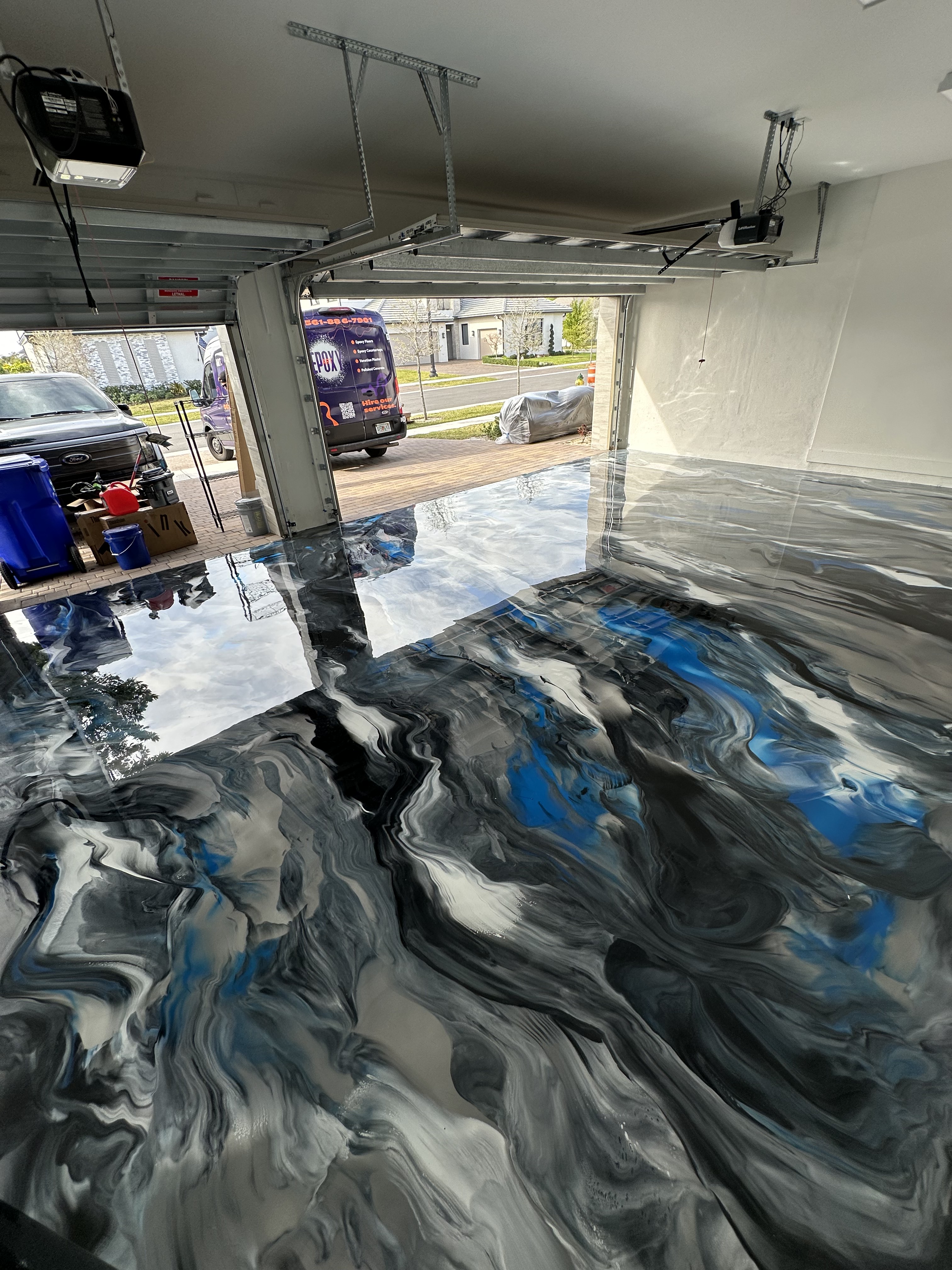 Glossy metallic epoxy floor with deep reflective copper and amber swirl movement
